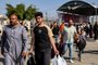 People walk through a gate to enter the Rafah border crossing to Egypt in the southern Gaza Strip on November 1, 2023. Scores of foreign passport holders trapped in Gaza started leaving the war-torn Palestinian territory on November 1 when the Rafah crossing to Egypt was opened up for the first time since the October 7 Hamas attacks on Israel, according to AFP correspondents. (Photo by Mohammed ABED / AFP)<!-- NICAID(15585220) -->