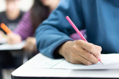 high school,university student study.hands holding pencil writing paper answer sheet.sitting lecture chair taking final exam attending in examination classroom.concept scholarship for education abroadFonte: 313224072<!-- NICAID(14793487) -->