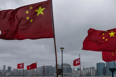 A man walks on a pier decorated with Chinese and Hong Kong flags to celebrate the 25th anniversary of the city's handover from Britain to China, in Hong Kong on July 1, 2022. (Photo by DALE DE LA REY / AFP)Editoria: POLLocal: Hong KongIndexador: DALE DE LA REYSecao: politics (general)Fonte: AFPFotógrafo: STF<!-- NICAID(15137402) -->
