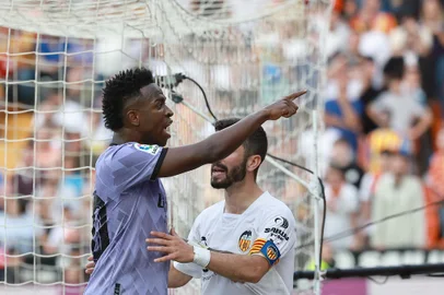 Real Madrid's Brazilian forward Vinicius Junior reacts to being insulted pointing at the stands during the Spanish league football match between Valencia CF and Real Madrid CF at the Mestalla stadium in Valencia on May 21, 2023. (Photo by JOSE JORDAN / AFP)<!-- NICAID(15434266) -->