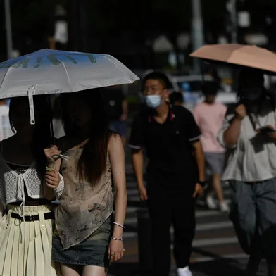 People walk along a street amid hot weather in Beijing on July 5, 2023. (Photo by Pedro PARDO / AFP)Editoria: WEALocal: BeijingIndexador: PEDRO PARDOSecao: reportFonte: AFPFotógrafo: STF<!-- NICAID(15474169) -->