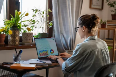Young female freelancer working learning from home at home using laptop with chart on screen. Remote work and online educationhome office. Foto: olezzo / stock.adobe.com Fonte: 571881601<!-- NICAID(15384690) -->