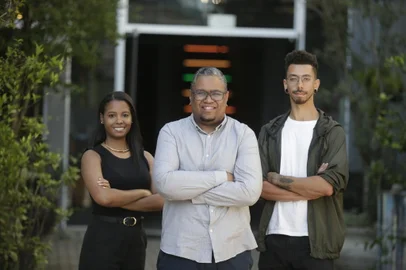 PORTO ALEGRE, RS, BRASIL, 07/11/2023- Classificados para a nacional da Expofavela. A Blaxp (um mix de das palavras black e experience) é uma startup educacional que promove cursos e capacitações, a pessoas físicas e empresas, através de professores e instrutores negros, com o intuito de capacitar e promover a diversidade nos mais diversos ambientes profissionais. A empresa foi fundada pelo publicitário pelotense Ezequiel Alvez, 38 anos, e é gerida com mais dois sócios. O empreendimento é um dos dez selecionados para a edição nacional da Expofavela, marcada para 1/12, em São Paulo. Na foto, (Esquerda) Marianne Gaspary, head de comunicação e marketing, 32. (Centro) Ezequiel Alvez, fundador/head de educação e negócios, 38 anos. (Direita) Mário Leão, head de audiovisual, 26 Foto: Lauro Alves  / Agencia RBS<!-- NICAID(15589702) -->