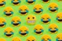 Scheme of yellow smiley pillows laughing at a smiley with a embarrassed grimace on a green background.Indexador: @soba.exeFonte: 495019760<!-- NICAID(15551378) -->