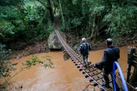 CAXIAS DO SUL, RS, BRASIL, 16/05/2024. Comunidade ilhada em Vila Cristina constrói pinguela para ter acesso a serviços básicos. Moradores passando na pinguela (Neimar De Cesero/Agência RBS)<!-- NICAID(15766052) -->