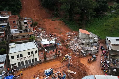 This aerial view shows rescue teams searching for victims amid the debris after a landslide caused by heavy rains in the Barrio Parque Jardim Burnier neighbourhood in Juiz de Fora, Minas Gerais State, Brazil, on February 24, 2026. Torrential rains in southeastern Brazil have left at least 25 people dead and 43 missing after a river burst its banks and a wall of mud swept away houses in the middle of the night, officials said on February 24. (Photo by Pablo PORCIUNCULA / AFP)<!-- NICAID(16233166) -->