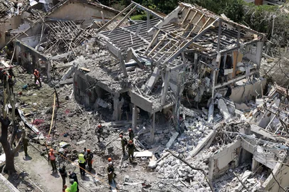 Israeli security forces and first responders gather at the site of an Iranian strike that hit a residential neighbourhood in the Ramat Aviv area in Tel Aviv on June 22, 2025. At least 16 people were hurt and at least one impact was reported in central Israel after Iran launched two waves of missiles at the country following the US bombing of its nuclear sites, rescue services and reports said. (Photo by Menahem KAHANA / AFP)<!-- NICAID(16064898) -->