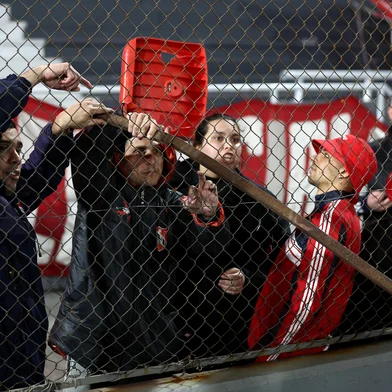 Fan of Independiente show a steel bar during the interruption of the Copa Sudamericana round of 16 second leg football match between Argentina's Independiente and Chile's Universidad de Chile at the Libertadores de America stadium in Avellaneda, Buenos Aires province, Argentina on August 20, 2025. (Photo by Alejandro PAGNI / AFP)<!-- NICAID(16106587) -->