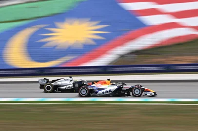 Racing Bulls' British driver Arvid Lindblad (R) and Cadillac's Mexican driver Sergio Perez (L) steer their cars during the first practice session ahead of the Formula One Bahrain Grand Prix in Sepang on October 2, 2026. (Photo by Jade Gao / AFP)<!-- NICAID(16378880) -->