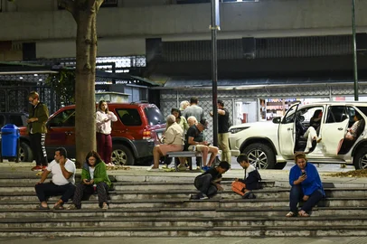 People sit at a public square after an earthquake was felt in Caracas, Venezuela, on September 25, 2025. A 6.3-magnitude quake shook northwestern Venezuela late Wednesday, following a slightly smaller tremor in the area, the US Geological Survey reported. The most recent earthquake was felt in the capital Caracas, more than 600 kilometres away. (Photo by Juan BARRETO / AFP)<!-- NICAID(16132331) -->