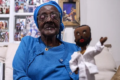 VIAMÃO, RS, BRASIL, 07-04-2026: Como a cultura de fãs se manifesta entre pessoas com mais de 60 anos. A reportagem procura entender de que maneira essa relação pode influenciar a vida ao longo dos anos e ganhar novos significados na terceira idade. Dona Nicolina, 95 anos, acabou se apaixonando pelo cantor Xande de Pilares, durante o período da pandemia. Todos os dias ela assiste ou ouve seus clipes e músicas, e já foi convidada a subir no palco e também a conhecer o cantor no camarim. Em sua casa, ela possui um mural de fotos com o registro desses encontros.  Foto: Bruno Todeschini/Agência RBS<!-- NICAID(16260957) -->