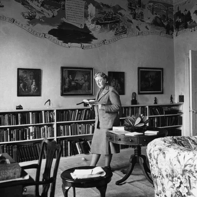 BIO-AGATHA CHRISTIE-LIBRARY-FRESCOESEnglish writer Dame Agatha Christie, reads in March 1946 a book in the library of her home, Greenway House, in Devonshire. The frescoes on the wall, painted by US Navy personnel during their WWII stay (when the house was lent to the US Navy) in Greenway House, depict the exploits of US Navy flotillas. Agatha Christie, born Miller (1890-1976) in Torquay, Devon, wrote, under the surname of her fist husband Colonel Archibald Christie (divorced in 1928) more than 70 detective novels featuring the Belgian detective, Hercule Poirot, or the inquiring village lady, Miss Marple. In 1930, Christie married Max E. L. Mallowan (1904-1978; knighted in 1968), professor of archaeology at London University (1947-78), with whom she travelled on several expeditions. Several of her stories have become popular films, such as "Murder on the Orient Express" (1974) and "Death on the Nile (1978). Christie was made a dame in 1971. (Photo by PLANET NEWS LTD / AFP)Editoria: ACELocal: GREENWAY HOUSESecao: literatureFonte: PLANET NEWS LTD<!-- NICAID(16047477) -->