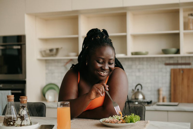 Beautiful curvy African woman enjoying healthy eating for lunch at homeBeautiful curvy African woman enjoying healthy eating for lunch at homeIndexador: G-STOCK STUDIOFonte: 669210363<!-- NICAID(15612926) -->