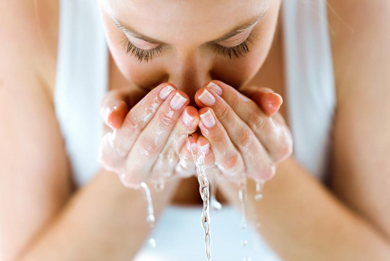Linda mulher jovem lavando seu rosto salpicando água em um banheiro em casaIndexador: LifestockFonte: 184863613<!-- NICAID(14325168) -->