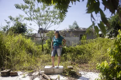 ESTRELA, RS, BRASIL, 04-03-2026: Ilga Maria Ledur Nicolau na área onde ficava sua casa, no bairro Moinhos. Bairros próximos às margens do Rio Taquari, em Estrela, devastados pela enchente de 2024 e atualmente classificados como área de alto risco para ocupação residencial devem ser transformados em parque linear, com área verde e espaços públicos para a população conviver perto do rio. O projeto da prefeitura do município prevê a implementação de Soluções Baseadas na Natureza (SBN), focados em resiliência climática e mitigação dos impactos de enchentes, especialmente após eventos climáticos extremos. Antigos moradores das áreas já foram removidos, mas alguns ainda aguardam pelas casas prometidas. Foto: Mateus Bruxel/Agência RBSIndexador: MATEUS BRUXEL<!-- NICAID(16239644) -->