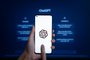 Phayao, Thailand - January 17 2023 : ChatGPT, Hand hold smartphone with AI chatbot by OpenAI open on website on laptop display screen on the background.Fonte: 562115476<!-- NICAID(15337196) -->