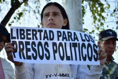 JACINTO OLIVEROS / AFP A woman shows a sign that reads "Freedom for political prisoners" during a demonstration to demand the freedom of Venezuelan political prisoners in front of Tocuyito prison in Tocuyito, near Valencia, Venezuela on January 20, 2026. Relatives of political prisoners reported on January 20, 2026, that some 200 people are in a state of "forced disappearance" in Venezuela and demanded proof of life from the prosecutor's office, amid a slow process of releases from prison under pressure from United States. (Photo by Jacinto OLIVEROS / AFP)<!-- NICAID(16209029) -->
