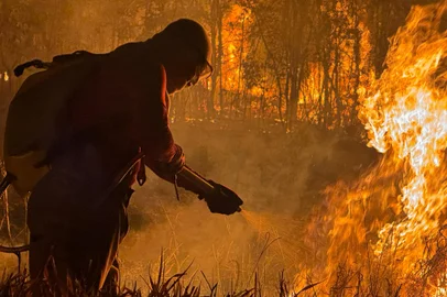 A firefighter extinguishes a fire in the municipality of Canta, Roraima state, Brazil, on February 29, 2024. (Photo by Alan CHAVES / AFP)Editoria: DISLocal: CantáIndexador: ALAN CHAVESSecao: fireFonte: AFPFotógrafo: STR<!-- NICAID(15693701) -->