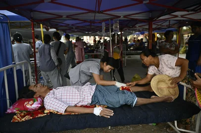 Earthquake survivor Tin Maung Htwe, who was rescued after five days of being trapped under the rubble of a collapsed building, is treated by medical personnel on an outdoor bed in the compound of a hospital in Sagaing on April 2, 2025, five days after a major earthquake struck central Myanmar. The shallow 7.7-magnitude earthquake on March 28 flattened buildings across Myanmar, killing more than 2,700 people and making thousands more homeless. (Photo by Sai Aung MAIN / AFP)<!-- NICAID(16008672) -->