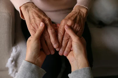 Cropped shot of elderly woman and female geriatric social worker holding hands. Women of different age comforting each other. Close up, background, copy space.Fonte: 601739881<!-- NICAID(15554708) -->