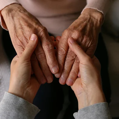 Cropped shot of elderly woman and female geriatric social worker holding hands. Women of different age comforting each other. Close up, background, copy space.Fonte: 601739881<!-- NICAID(15554708) -->
