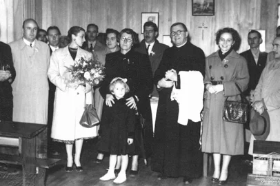 Considerado um dos pioneiros da indústria têxtil em Caxias do Sul, o industrialista italiano Matteo Gianella (1883-1942) também teve sua memória e trajetória homenageadas pela Instrução Pública do Município. Foi em maio de 1953, época em que a professora Ester Troian Benvenutti atuava como diretora da pasta.Conforme destacado pelo Pioneiro de 9 de maio de 1953, a denominação oficial do nome Matteo Gianella a uma escola do município ocorreu durante uma solenidade em 3 de maio de 1953, na Zona Pigatto, localidade de Santo Homo Bom, em Ana Rech. Participaram da cerimônia o prefeito Euclides Triches e a esposa, Neda Ungaretti Triches, representantes do Executivo e do Legislativo, além vários integrantes da família Gianella: a viúva Ermelinda Viero Gianella, os filhos do casal (Doviglio, Remo, Itália e Elite), Mary Pezzi Gianella (esposa de Remo, com a filha Leila Maria) e Tarcisio Tonolli (marido de Elite), entre outros. Na foto: A inauguração da escola em 3 de maio de 1953: a partir da esquerda, o prefeito  Euclides Triches, Doviglio Gianella (ao fundo), a primeira-dama Neda Ungareti Triches, Ermelinda Viero Gianella (viúva de Matteo), Remo Gianella, o padre Jerônimo Rossi (vigário de Ana Rech) e Mary Pezzi Gianella, esposa de Remo. A menina é Leila Maria Gianella, filha de Remo e Mary.<!-- NICAID(15712270) -->