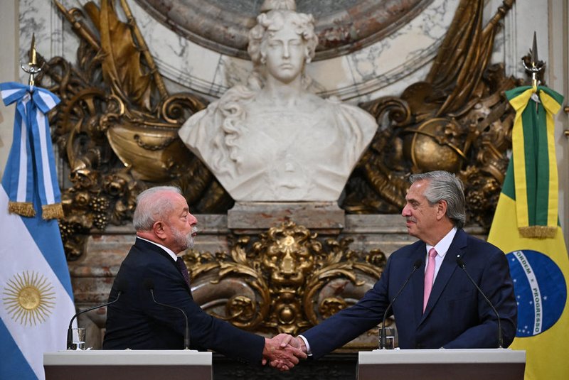 Brazilian President Luiz Inacio Lula da Silva (L) and Argentine President Alberto Fernandez (R) shake hands during a press conference at the Casa Rosada presidential palace in Buenos Aires on January 23, 2023. - Brazil's President Luiz Inacio Lula da Silva began his first international tour last Sunday with a visit to Argentina and Uruguay with the aim of restoring regional leadership to Brazil after the management of the far-right Jair Bolsonaro. (Photo by Luis ROBAYO / AFP)<!-- NICAID(15328973) -->