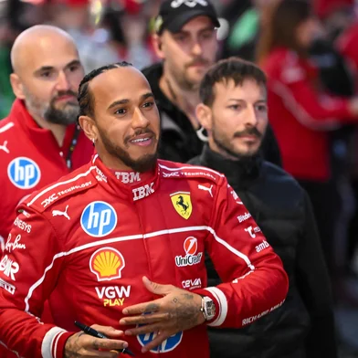 (FILES) British F1 driver Lewis Hamilton signs autographs during the Scuderia Ferrari HP Drivers' presentation event by Unicredit, in Piazza Castello in Milan, on March 6, 2025. The 2025 Formula One season marking 75 years since the inaugural seven-race championship in 1950, begins on March 14 with the Australian Grand Prix. (Photo by Piero CRUCIATTI / AFP)<!-- NICAID(15993152) -->