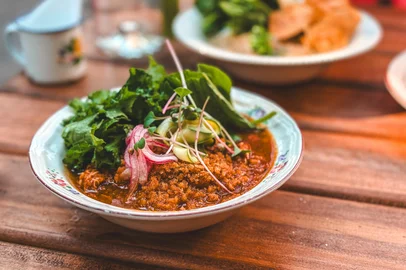 Galinhada: sobrecoxa desfiada, arroz cateto, sofrito, demi glace, picles de cebola roxa, aioli, mix de folhas e farofa da casa.<!-- NICAID(16098882) -->