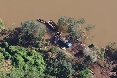 Contrabandistas usam barcos para atravessar o rio Uruguai e descarregar a soja em caminhões, no lado brasileiro da fronteira