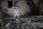 A chair sits outside a burnt house in Kibbutz Beeri near the border with the Gaza Strip on October 15, 2023, after the October 7 attack by Palestinian militants. In the eight days since Hamas gunmen killed more than 1,300 Israelis in a surprise attack, Israel has responded with a bombing campaign that has claimed over 2,300 lives in Gaza. (Photo by YURI CORTEZ / AFP)<!-- NICAID(15569102) -->
