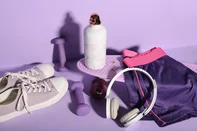 Composition with different sports equipment, shoes and bottle of water on lilac background<!-- NICAID(16340157) -->