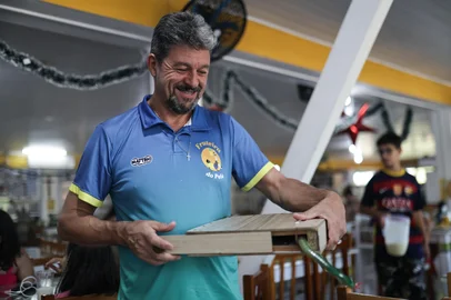 TORRES, RS, BRASIL, 10-01-2026: Humor e culinária clássica da estrada, a receita de sucesso da Fruteira do Pelé. Suco infinito, piadas e caixa misteriosa: conheça Pelé, o "fruteiro" que diverte e alimenta quem passa pela Estrada do Mar. Foto: Renan Mattos / Agência RBS<!-- NICAID(16201737) -->