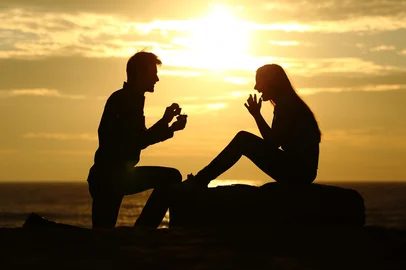 Proposal on the beach with a man silhouette asking for marry at sunset with the sun in the backgroundFonte: 81347616<!-- NICAID(16154641) -->