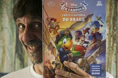 Porto Alegre, RS, Brasil, 28-03-2023: Eduardo Bueno, o Peninha, com o livro Zé Carioca conta a história do Brasil, com textos e roteiros dele, em casa, em Porto Alegre. Foto: Mateus Bruxel / Agência RBSIndexador: Andre Avila<!-- NICAID(15387425) -->