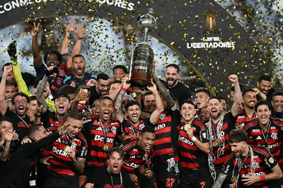 Flamengo's forward #27 Bruno Henrique (R) and Uruguayan midfielder #10 Giorgian de Arrascaeta (L) lift the the trophy with teammates after winning the all Brazilian Copa Libertadores final football match between Palmeiras and Flamengo at Monumental 'U' Marathon stadium in Lima on November 29, 2025. (Photo by Luis ACOSTA / AFP)Editoria: SPOLocal: LimaIndexador: LUIS ACOSTASecao: soccerFonte: AFPFotógrafo: STF<!-- NICAID(16177070) -->