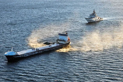 This handout photo received via Lehtikuva from the Finnish police shows a Border Guard helicopter and the Coast Guard patrol ship "Turva" (R) seizing the "Fitburg" vessel suspected of a subsea cable breach in the Gulf of Finland on 31 December 2025. Finnish police said they had seized a vessel suspected of damaging a telecommunications cable that runs between Helsinki and Tallinn in the Gulf of Finland several hours earlier. The Finnish coast guard identified the vessel as the Fitburg, a 132-meter-long cargo ship bearing a flag from St Vincent and Grenadines, en route from St Petersburg, Russia, to Haifa, Israel. Fourteen crew members from Russia, Georgia, Azerbaijan and Kazakhstan were detained and were to be questioned. (Photo by Handout / various sources / AFP) / - Finland OUT / - FINLAND OUT /  - FINLAND OUT / RESTRICTED TO EDITORIAL USE - MANDATORY CREDIT "AFP PHOTO /  FINNISH POLICE " - HANDOUT - NO MARKETING NO ADVERTISING CAMPAIGNS - DISTRIBUTED AS A SERVICE TO CLIENTS<!-- NICAID(16196636) -->