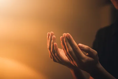 Hand praying on orange light bokeh background.OraçãoFonte: 578208230<!-- NICAID(16039323) -->