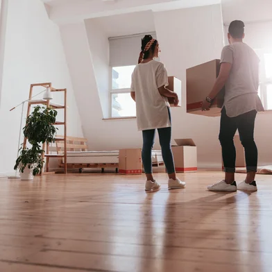 Young couple moving in new houseFull length rear view shot of young couple carrying cardboard box at new home. Young man and woman holding boxes and moving in new house.Indexador: Jacob Ammentorp LundFonte: 164972444<!-- NICAID(16142484) -->
