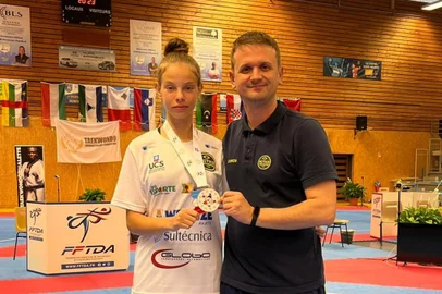 Nicole Caetano, atleta de 16 anos da ACTKD, conquistou medalha de bronze em sua primeira comeptição internacional - Na foto, junto com o treinador Daniel Brisotto<!-- NICAID(15802759) -->