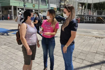 Ação da Rede de Proteção à Mulher em situação de violência doméstica na esquina das ruas Sinimbu e Dr. Montaury. Na foto, a delegada Aline Martinelli, de camiseta rosa; a policial civil Vanessa Kohler; e a doméstica Marilei Correa de Oliveira. <!-- NICAID(15035853) -->