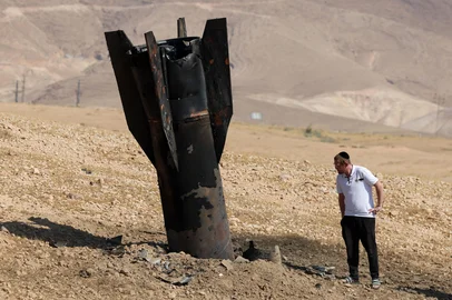A man checks a fallen rocket half-buried in the ground on the outskirts of Jericho on June 8, 2026, following Iranian and Iran-backed Houthi rebel attacks. Israel and Iran traded fire on June 8, seriously testing a fragile truce and threating hopes for a deal to end the Middle East war. (Photo by Ahmad GHARABLI / AFP) / Editoria: WARLocal: JerichoIndexador: AHMAD GHARABLISecao: warFonte: AFPFotógrafo: STF<!-- NICAID(16301497) -->