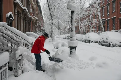 A person clears snow from the sidewalk during a winter storm in the Brooklyn borough of New York City on February 23, 2026. New York ordered drivers off the road and shut down schools on Monday, while residents hunkered down for a massive snowstorm hitting the United States northeast. The National Weather Service (NWS) said in a post on X that "heavy snow is still falling" at 5:28 am local time (1028 GMT) on Monday adding that a the total snowfall stands at 14.9 inches. (Photo by ANGELA WEISS / AFP)Editoria: WEALocal: New YorkIndexador: ANGELA WEISSSecao: reportFonte: AFPFotógrafo: STF<!-- NICAID(16230961) -->