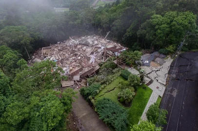 O Residencial Condado Ana Carolina, que tinha risco de desabar desde o último domingo (19), em Gramado, caiu por volta das 5h38min desta quinta feira (23). Construído em uma encosta na Rua Ladeira das Acácias, o condomínio fica no bairro Planalto e acima do bairro Três Pinheiros. Os moradores saíram do local devido ao risco de desabamento da estrutura.Fotógrafo: Neimar De Cesero/Agencia RBS<!-- NICAID(15606528) -->
