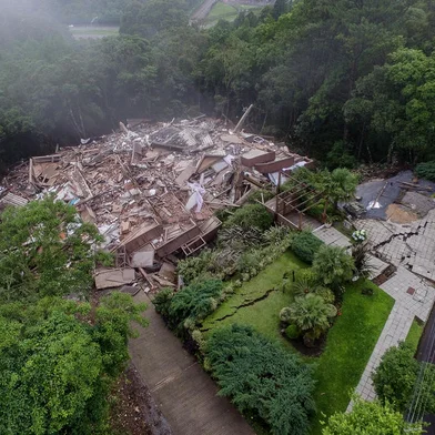 O Residencial Condado Ana Carolina, que tinha risco de desabar desde o último domingo (19), em Gramado, caiu por volta das 5h38min desta quinta feira (23). Construído em uma encosta na Rua Ladeira das Acácias, o condomínio fica no bairro Planalto e acima do bairro Três Pinheiros. Os moradores saíram do local devido ao risco de desabamento da estrutura.Fotógrafo: Neimar De Cesero/Agencia RBS<!-- NICAID(15606528) -->