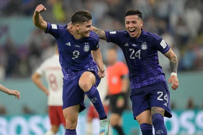 Argentina's forward #09 Julian Alvarez (L) celebrates with Argentina's midfielder #24 Enzo Fernandez after he scored his team's second goal during the Qatar 2022 World Cup Group C football match between Poland and Argentina at Stadium 974 in Doha on November 30, 2022. (Photo by JUAN MABROMATA / AFP)Editoria: SPOLocal: DohaIndexador: JUAN MABROMATASecao: soccerFonte: AFPFotógrafo: STF<!-- NICAID(15301580) -->