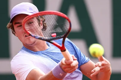 Brazil's Joao Fonseca plays a forehand return to 's Pierre-Hugues Herbert during their men's singles match on day 5 of the French Open tennis tournament at the Roland-Garros Complex in Paris on May 29, 2025. (Photo by Anne-Christine POUJOULAT / AFP)<!-- NICAID(16048219) -->