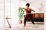 Full length of healthy woman exercising at home watching online video on laptop. Beautiful female in sports wear doing yoga.Indexador: Gabriel MaiaFonte: 442679488<!-- NICAID(15611751) -->