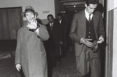 Caso Kliemann - Deputado Euclides Kliemann (chapéu), saindo do depoimento na Delegacia de Segurança Pessoal.          A sociedade gaúcha, principalmente os meios políticos, foi agitada por uma notícia bombástica na noite de 20 de junho de 1962. No hall de entrada do palacete onde morava, no bairro Moinhos de Vento, em Porto Alegre, foi encontrado o corpo de Margit Kliemann, mulher do deputado estadual Euclides Kliemann (PSD). Havia sido morta a golpes de objeto contundente, segundo apuraram os peritos. Era o início de um dos maiores mistérios policiais do século, no Rio Grande do Sul.                     Euclides Kliemann chegou a constar da lista de suspeitos do assassinato de sua mulher, Margit (D). No ano seguinte, o deputado estadual seria morto a tiros por um vereador de Santa Cruz do Sul.          O crime foi reconstituído, segundo as investigações policiais, mas, mesmo assim, o caso Kliemann entrou para a lista dos insolúveis.-#FOTÓGRAFO:Waldomiro Soares#Envelope: 21589 (acervo Última Hora)<!-- NICAID(3627135) -->