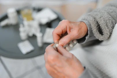 Close up of an elderly hand holding pills.<!-- NICAID(16175743) -->